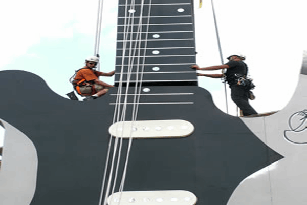Crew installing a giant guitar stage prop for Rock2Wgtn in Wellington.