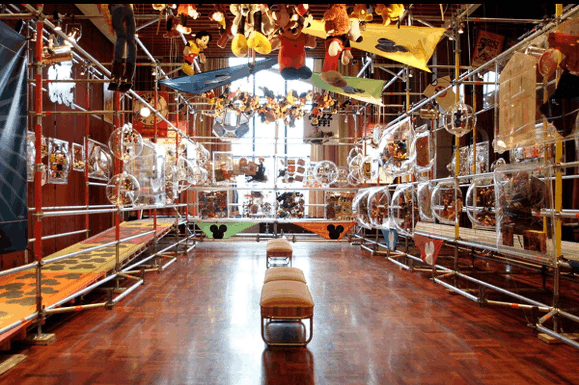 Interior view of The Great Disney Toy Exhibition with large display pieces and suspended Disney characters.